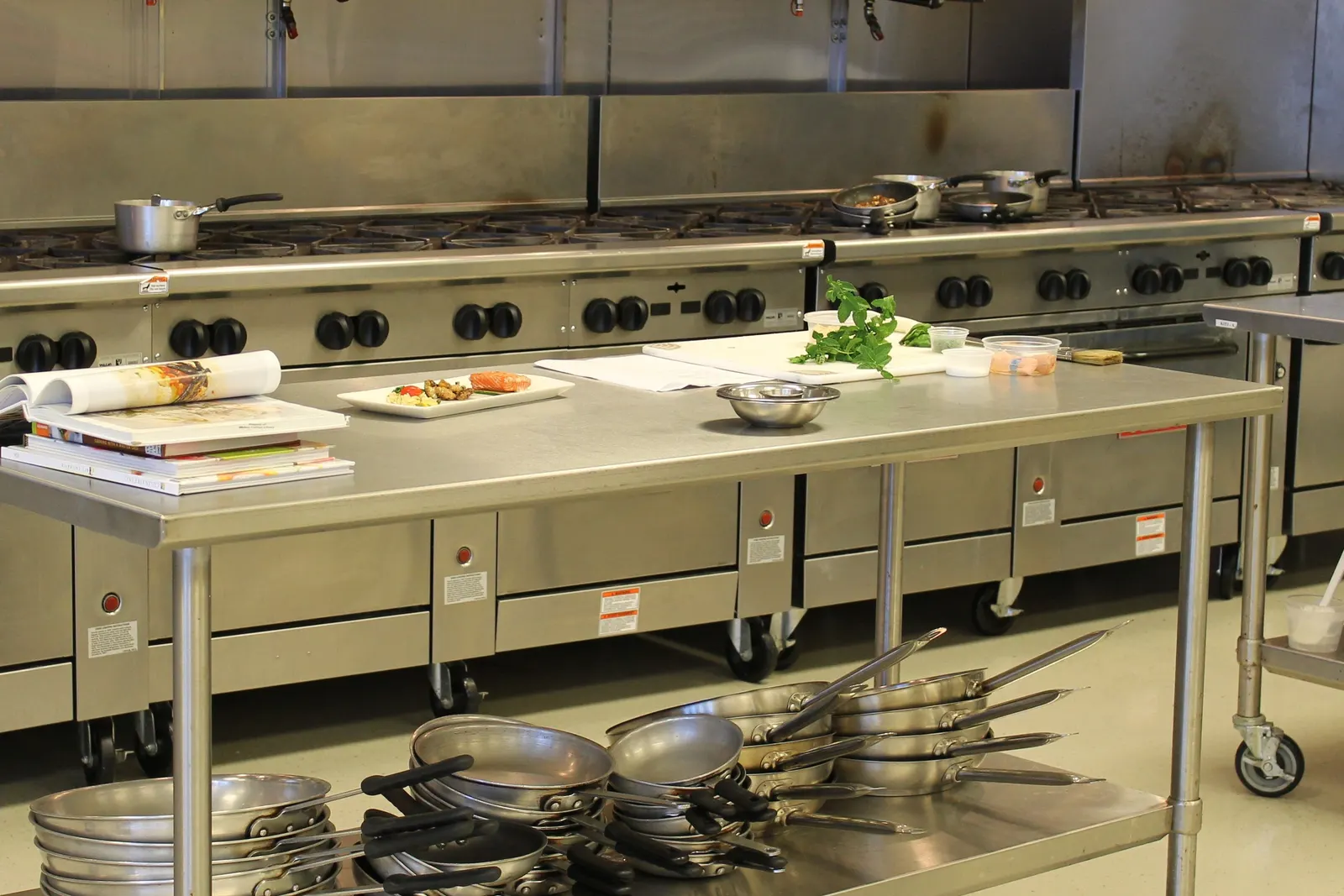 Cocina profesional de acero inoxidable con fogones industriales y mesa de trabajo